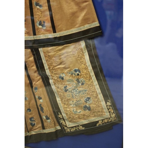 399 - A CHINESE PLEATED SKIRT with black silk satin gores, and blue embroidered foliate panels, with couch... 