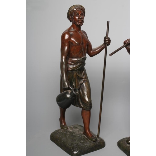 400 - A PAIR OF PAINTED SPELTER ARAB MALE WATER CARRIERS, after Marcel Debut (1865-1933) each modelled sta... 