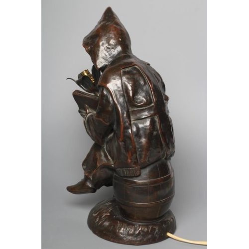 401 - A BRONZED METAL FIGURAL TABLE LAMP, 20th century, modelled as a hooded child seated on a barrel, hol... 