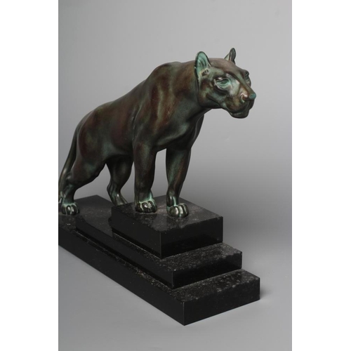 403 - AN ART DECO BRONZED SPELTER LIONESS modelled standing with alert expression, green patination, raise... 