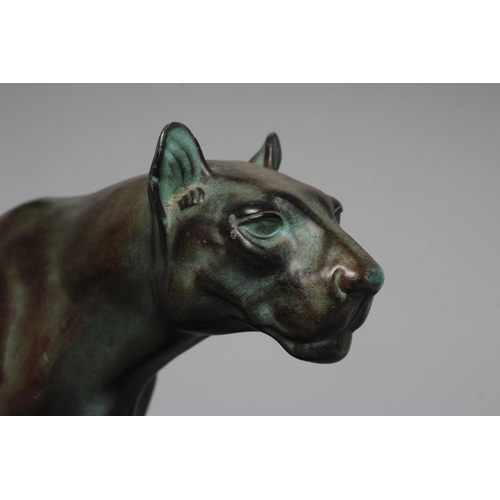 403 - AN ART DECO BRONZED SPELTER LIONESS modelled standing with alert expression, green patination, raise... 