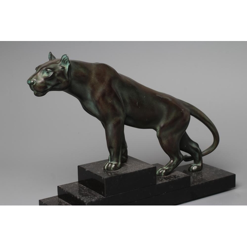 403 - AN ART DECO BRONZED SPELTER LIONESS modelled standing with alert expression, green patination, raise... 