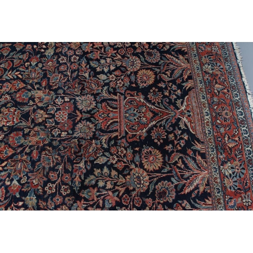 412 - A PERSIAN RUG, 20th century, the navy blue mirhab with vase and flowers, red and ivory floral corner... 