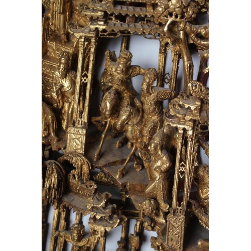 414 - A CHINESE CARVED AND PIERCED GILTWOOD PANEL, featuring a garden pavilion with noble figures flanked ... 