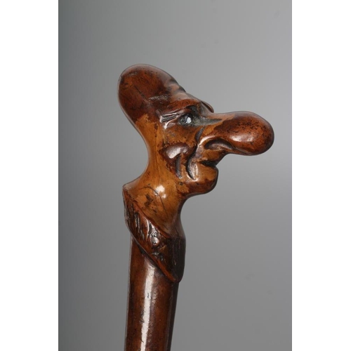 427 - TWO GROTESQUE NOVELTY WALKING CANES, comprising a thorn cane with antler tip carved with two faces, ... 