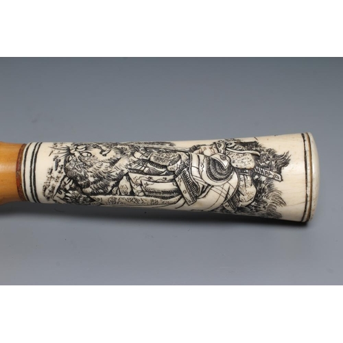 431 - A JAPANESE WALKING CANE, the bone grip carved in relief with a Samurai killing a tiger, bamboo shaft... 