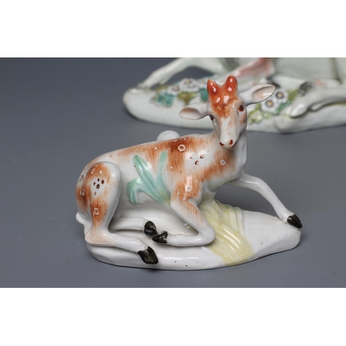 44 - A DERBY PORCELAIN STAG AND HIND, c.1760, each modelled recumbent on a flower encrusted shaped base, ... 