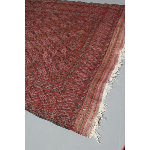 442 - A PERSIAN TRIBAL RUG, the soft red ground with trellis patterned field in shades of grey, within a z... 