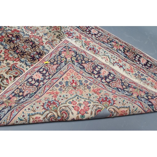 444 - A PERSIAN RUG, 20th century, the ivory and camel floral field centred by a navy blue gul all in shad... 