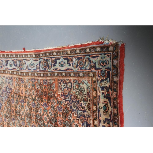 445 - A PERSIAN RUG, 20th century, the red floral field with navy blue centre gul and spandrels, with navy... 