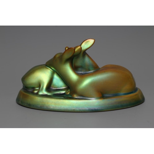 77 - A ZSOLNAY PECS GREEN IRIDESCENT POTTERY MODEL, mid 20th century, of two recumbent deer, printed gilt... 