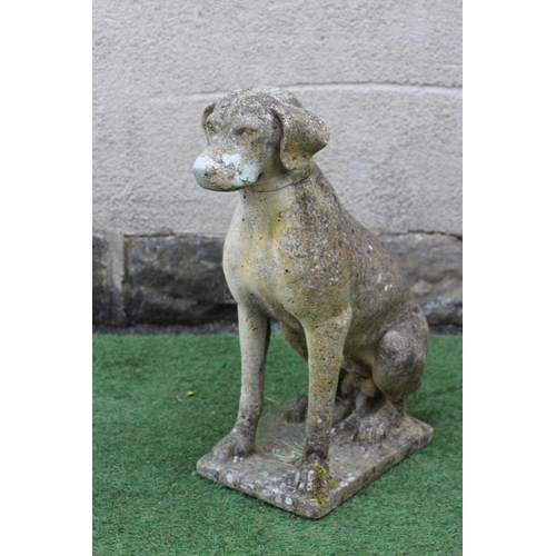 740 - A CAST STONE FIGURE OF A SEATED DOG on an oblong plinth, 18