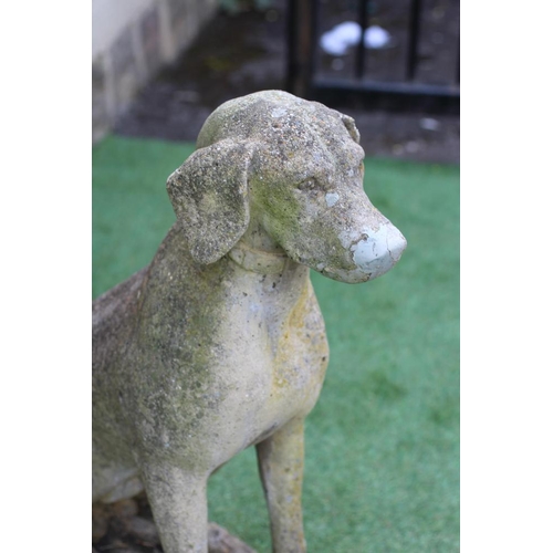 740 - A CAST STONE FIGURE OF A SEATED DOG on an oblong plinth, 18