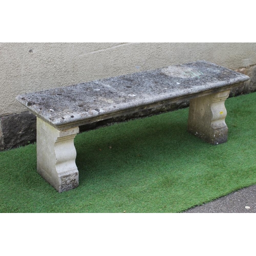 741 - A CAST STONE BENCH, the moulded edged oblong seat raised on flower moulded square section end supppo... 