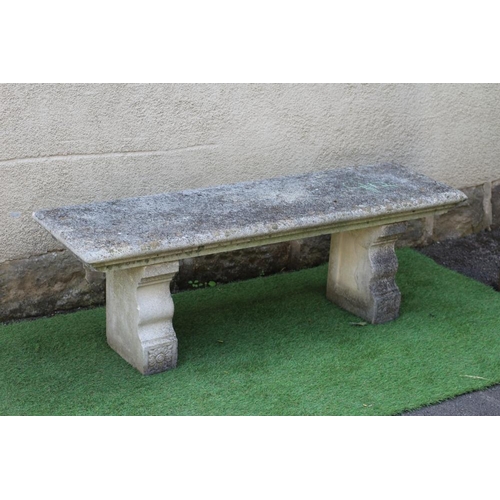 742 - A CAST STONE BENCH, the moulded edged oblong seat raised on flower moulded square section end suppor... 