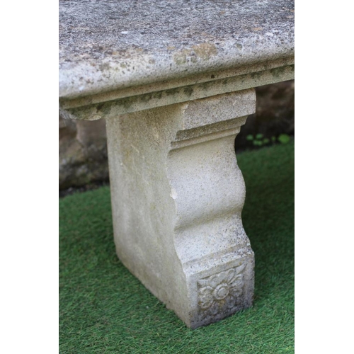 742 - A CAST STONE BENCH, the moulded edged oblong seat raised on flower moulded square section end suppor... 