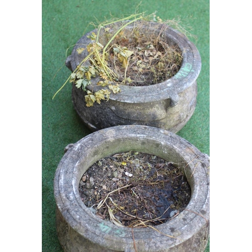 744 - A PAIR OF CAST STONE PLANTERS of cauldron form, the moulded rim with three handles over a band of fl... 