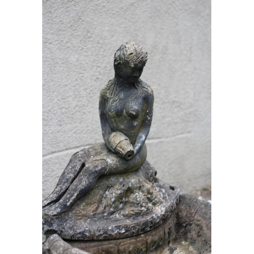 747 - A CAST STONE WATER FEATURE modelled as an escallop shell surmounted by a seated nymph with water ves... 