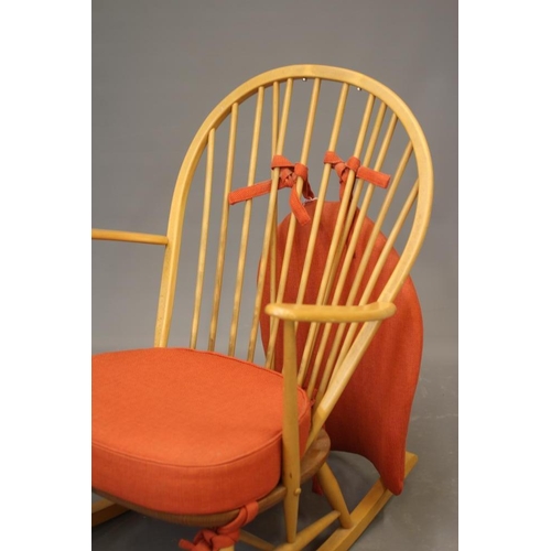 802 - AN ERCOL MODEL 316 ROCKING CHAIR, mid 20th century, in blond beech and elm, with loose cushions in a... 