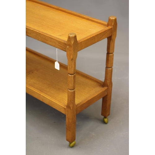 819 - MALCOLM PIPES, AN ADZED OAK TEA TROLLEY of oblong two tier form raised on four square turned faceted... 