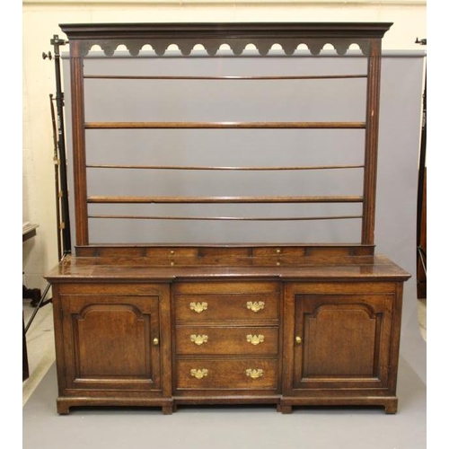 868 - A GEORGIAN OAK ENCLOSED DRESSER, late 18th century, of inverted breakfront form, the moulded edged t... 