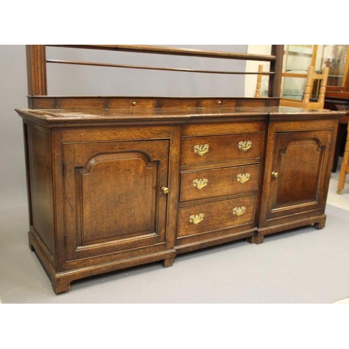 868 - A GEORGIAN OAK ENCLOSED DRESSER, late 18th century, of inverted breakfront form, the moulded edged t... 