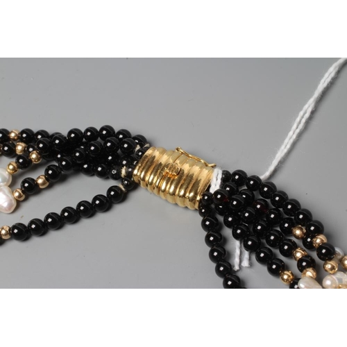 179 - AN ONYX BEAD AND FRESHWATER PEARL FIVE STRAND NECKLACE to a reeded clasp stamped 750, EJ (Est. plus ... 