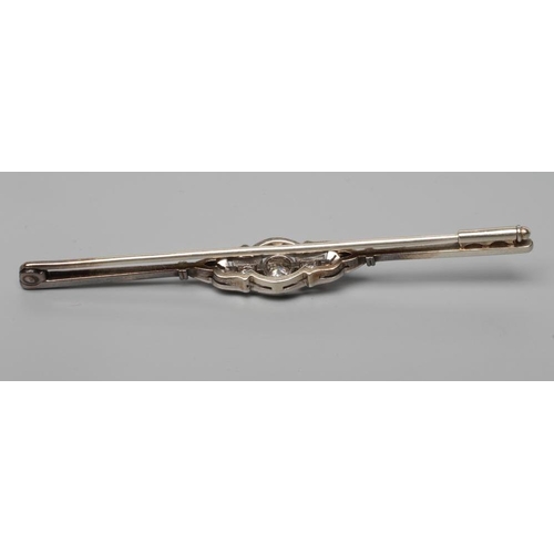 184 - A DIAMOND BAR BROOCH centred by a collet set brilliant cut stone of approximately 0.20cts flanked by... 