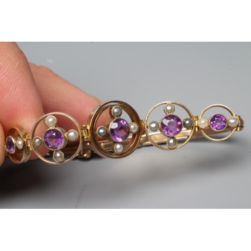 188 - AN EDWARDIAN AMETHYST AND SEED PEARL BRACELET, the five graduated open circlets each centred by a co... 