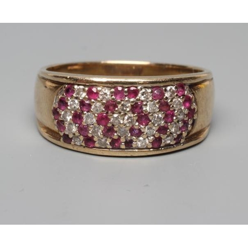 191 - A RUBY AND DIAMOND DRESS RING, the oval panel point set with numerous small diamonds and rubies to a... 