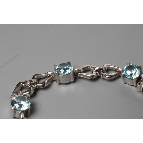 198 - A BLUE TOPAZ BRACELET, the eight facet cut circular stones with pairs of 9ct white gold triangular o... 