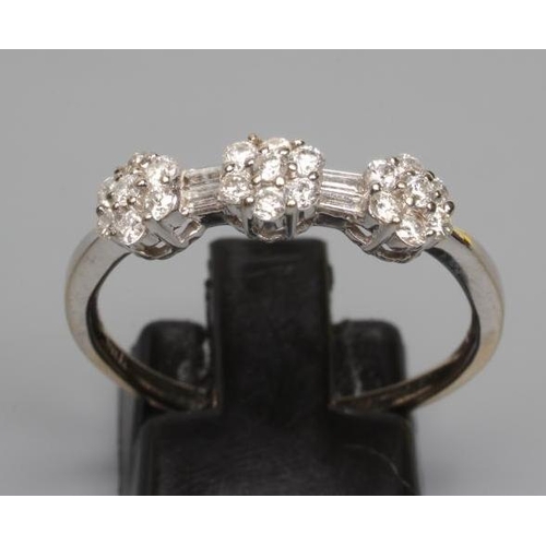 199 - A DIAMOND TRIPLE CLUSTER RING, the seven stone small clusters with two pairs of baguette cut stones ... 