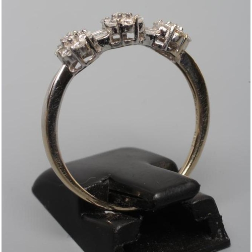 199 - A DIAMOND TRIPLE CLUSTER RING, the seven stone small clusters with two pairs of baguette cut stones ... 