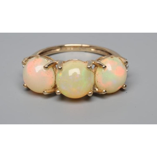 203 - A THREE STONE OPAL RING, the round cabochon polished stones claw set to a plain 14ct gold shank, siz... 