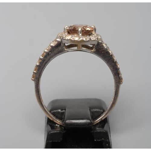 225 - A CHAMPAGNE DIAMOND CLUSTER DRESS RING, the central round brilliant cut stone of approximately 0.80c... 