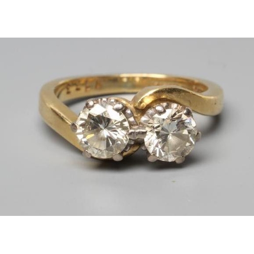 239 - A TWO STONE CROSSOVER DIAMOND RING, the old brilliant cut stones each of approximately 0.50cts, claw... 