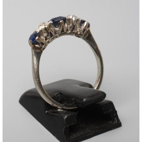 251 - A FIVE STONE SAPPHIRE AND DIAMOND HALF HOOP RING, the three sapphires and two round brilliants claw ... 