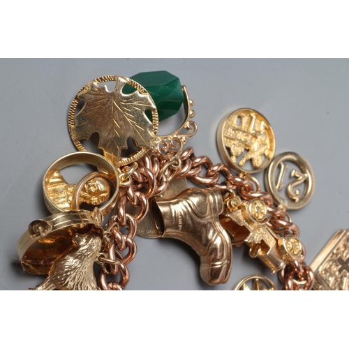 265 - A 9CT GOLD CURB LINK CHAIN BRACELET with padlock fastener, hung with eighteen charms including eagle... 