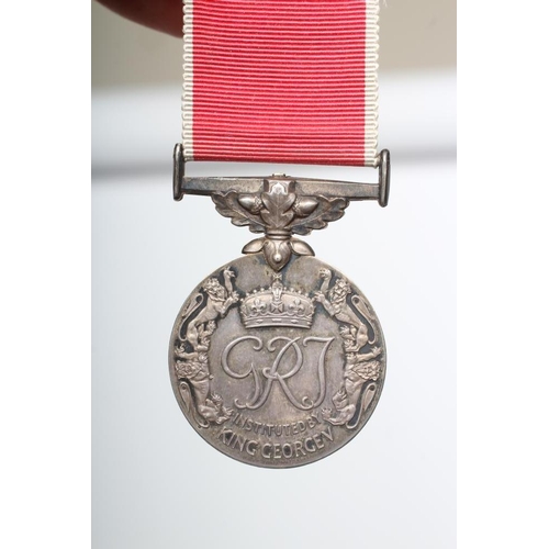 473 - AN EMPIRE MEDAL with George V monogram and red ribbon with white edges, named 