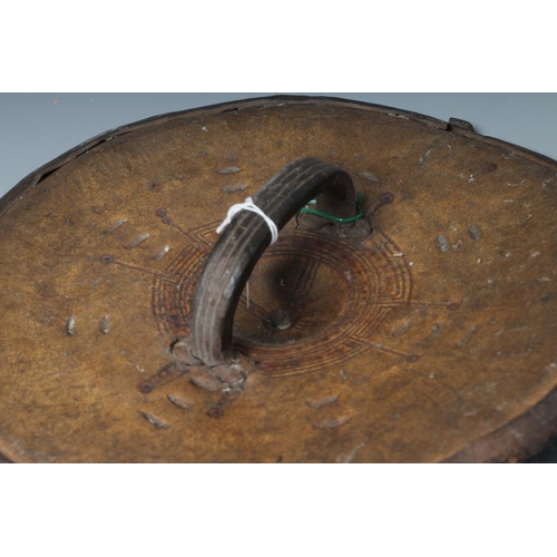 490 - TWO AFRICAN HIDE SHIELDS, possibly Somalian, of circular form, with embossed geometric design and th... 