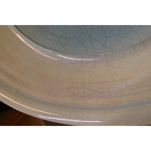 80 - JOHN DUNN (b.1944) - a large Raku iridescent turquoise glazed stoneware circular dish, signed, 22