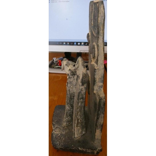 81 - JOHN MALTBY (1936-2000) - a matt grey stoneware sculpture of two figures standing before a cut slab ... 