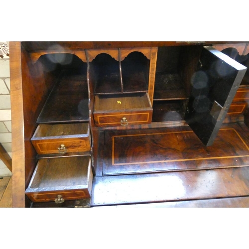 837 - A GEORGIAN WALNUT BUREAU, third quarter 18th century, the banded fallfront with stringing enclosing ... 