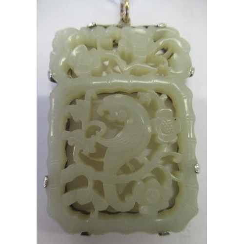 375 - A CHINESE JADE OBLONG DOUBLE SIDED PANEL, carved and pierced with a parrot type bird amidst flowerin... 