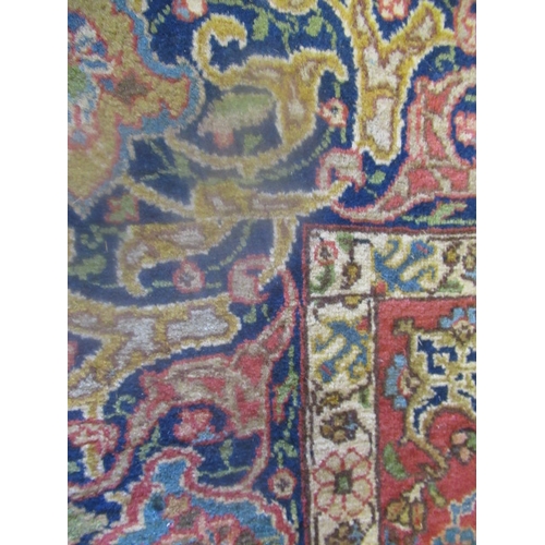 422 - A PERSIAN RUG, early 20th century, the red floral field with central navy blue gul, navy blue main b... 