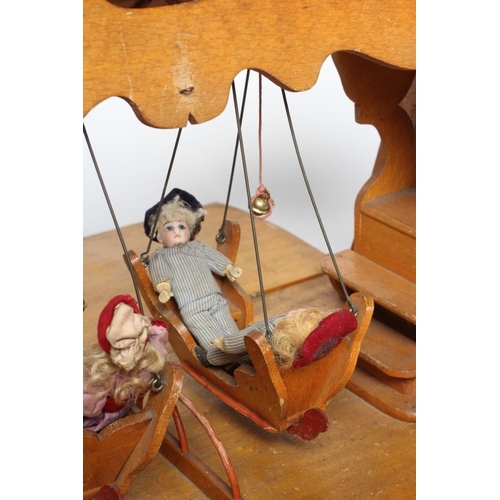 129 - An early 20th century musical doll's swing boat set ensuite with six French dolls, the swing set of ... 