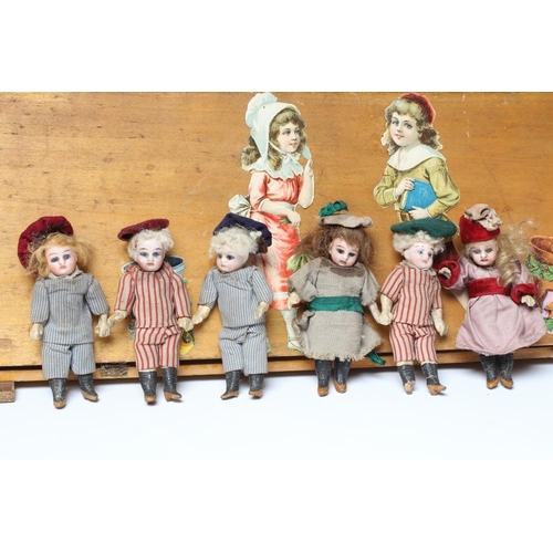 129 - An early 20th century musical doll's swing boat set ensuite with six French dolls, the swing set of ... 