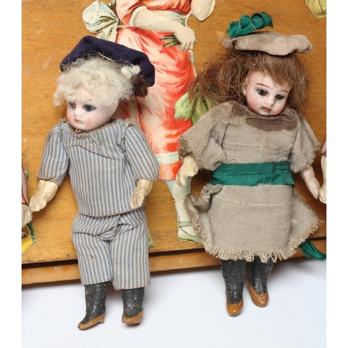 129 - An early 20th century musical doll's swing boat set ensuite with six French dolls, the swing set of ... 