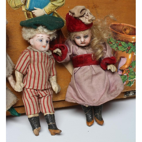 129 - An early 20th century musical doll's swing boat set ensuite with six French dolls, the swing set of ... 