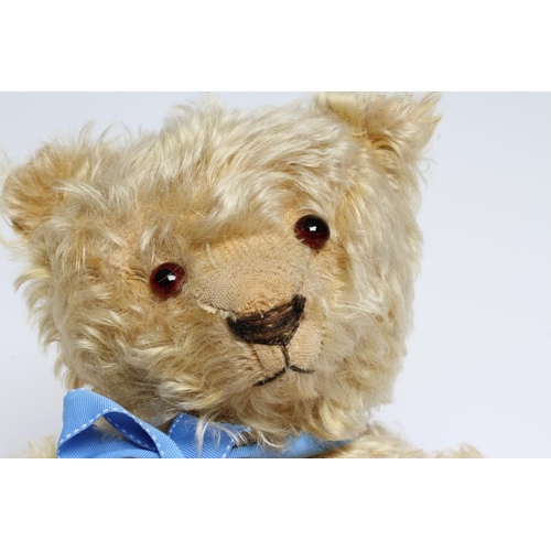 162 - A pre-war teddy bear, with amber glass eyes, sewn nose, long orange plush and felt pads, 19 1/2